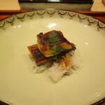 301743900 - 青鰻：三河一色産 一年物の青鰻を甘辛く、芳ばしく、ふっくらと焼きたてで岐阜 “はつしも“（白飯）と一緒にいただきます。上には木の芽が添えられています。