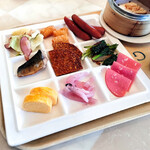 ルッチコーレ - おかず ベーコンキャベツ、一口ハッシュドポテト、ウインナー、鯖塩焼き、フィッシュカツ、じゃこ天と小松菜炒め、出汁巻き玉子、淡路島産玉葱梅しそ漬け、ソフトサラミ