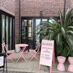 SHARE - お店の外には映えそうなピンクのテーブルと椅子。