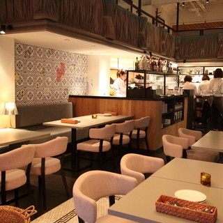 １階席。吹き抜けのある開放的な空間。パリの居酒屋風。落ち着く雰囲気の照明。