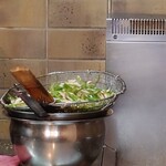 月泉 - カウンター席から湯通しされた豚肉たとピーマンを撮影。