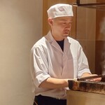 温石 - 炭焼き台に向かう店主