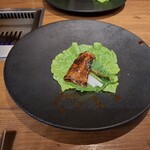 焼肉うしごろ - 赤いタレに漬け込んだ大分県産の特選サーロインを、網の鉄板で焼いた後サンチュ、大葉、葉唐辛子、アスパラガスのピクルスの上にのせた様子のその4です。