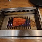 焼肉うしごろ - 赤いタレに漬け込んだ大分県産の特選サーロインを、網の鉄板の上で焼いている様子のその7です。
