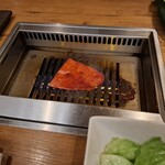 焼肉うしごろ - 赤いタレに漬け込んだ大分県産の特選サーロインを、網の鉄板の上で焼いている様子のその4です。