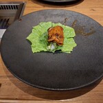 焼肉うしごろ - 赤いタレに漬け込んだ大分県産の特選サーロインを、網の鉄板で焼いた後サンチュ、大葉、葉唐辛子、アスパラガスのピクルスの上にのせた様子のその3です。