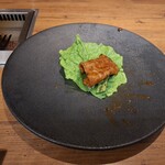 焼肉うしごろ - 赤いタレに漬け込んだ大分県産の特選サーロインを、網の鉄板で焼いた後サンチュ、大葉、葉唐辛子、アスパラガスのピクルスの上にのせた様子のその5です。