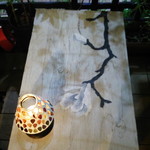 マグノリアカフェ - お店のマスターがテラス・テーブル描いた花