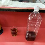 栄楽 - カウンター席に案内され、麦茶がグラスで提供されたけど、、、 ①麦茶入りの２Lペットボトルも一緒に渡されます。(笑)