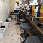 豚ギャング - 内観 正面のカウンター10席 壁側にハンガー、荷物入れ、ゴミ箱があります