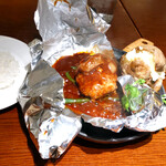 グリルキャピタル東洋亭 - ナイフでアルミホイルを切ってからいただきます。湯気があふれ出してきました