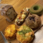 TOAST - 左上からサヤキレーズン食パンハーフ、左下エビとタマゴのハムロール、左上中ラタトゥイユ、右下サーモンジェノベーゼのハムロール、右中くるみあんぱん、右上　焼きドーナツ抹茶