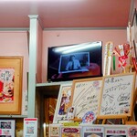 味楽 - 店内右奥の冷蔵庫上にもサイン色紙。