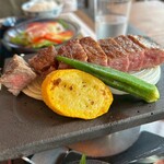 307074320 - 陶板に敷かれた淡路産玉ねぎの上に横たわる椚座牛サーロインは「静かに語る」ような存在感を放つ