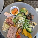 ブッフェダイニングシェフズレシピ - 中央にサラダ、上から時計回りによだれ鶏、茄子、きのこのキヌア和え、ブロッコリーのリコッタソース、かぼちゃ、鴨のテリーヌオレンジ風味、空豆入りソップレッサータ生ハム、サーモンのアボカドソース。