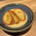 おでんと炉端 たけし - ガーリックトーストは、目の前で鶏だしをかけてくれる。これ、めちゃくちゃ美味い！一人前ずつ締めにもいい！