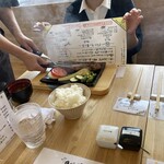たちばなのバーグステーキ 本店と工房 - 説明書きの書かれた紙を油よけに使う、今までの経験ではナプキンを使うパターンだったので、これは初めて‼️
