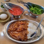 カリー フランキー軒 - 骨付きチキンカリー＋生玉子 1050円(税込)  薬味のパクチーミックス､トマト､青唐辛子は客席2人に１つ配置されている｡