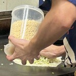 鉄板焼 OMURAYA - 天かすも乗せて崩れないよう押さえます。