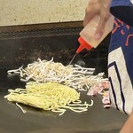 鉄板焼 OMURAYA - 続いては焼きそばの実況！
      麺と豚肉、もやしを鉄板に乗せます。