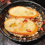 月島もんじゃ もへじ - アヒージョオイルにバゲット入れて、アレンジガーリックトーストに。悶絶のうまさ。