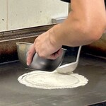 鉄板焼 OMURAYA - ここからはネギすじ焼きの実況！
      まずは鉄板に生地を丸く伸ばします。