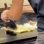 鉄板焼 OMURAYA - そして焼きそば麺に両手のテコを立ててカカカカカッと細かく刻んでいきます。