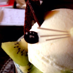 ことばのはおと - フレッシュキウイの初恋にゃんこパフェ（800円）の右前脚、近影。極薄の板チョコにホワイトチョコレートで肉球も。