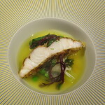 Restaurant KAITO - スジアラ：小笠原で獲れたスジアラ（ハタの仲間）にディルの衣を薄く付け、揚げてからカットして、周囲にツルムラサキ、冬瓜、蕪の千切り、グリンピース、新生姜、クスクスがあしらわれ、サフランで香り付けしたブイヨンでスープ仕立てにしてあります。