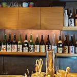 是屋 - 壁には銘酒の瓶が揃う。