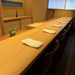 米増 - 白木のカウンターと居心地の良い椅子がお出迎え。