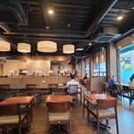 タリーズコーヒー - 店内は黒塗り剥き出し高天井、ベージュ色の壁&ガラス張り壁、ベージュ色のタイルとグレーのタイル貼り床、天井が高いので圧迫感がなく居心地の良い空間、BGMはJAZZ