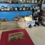 ハクナマタタ - カウンターから…メニュー表は赤い表紙が印象的