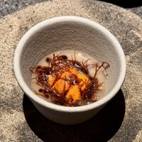 アニエルドール - 北海道産ミル貝と鳥取産もずく、小芋のピクルスがそっと器の底に忍び、上からは小芋のスープがとろりとかけられています。中央には生雲丹がそっと鎮座し、仕上げに柚子味噌の香りを纏ったオイルが余韻を演出。