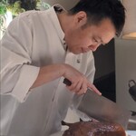 眞善美 - 北京ダック：こんがりとあめ色に焼かれた大きな北京ダックを 可合シェフが目の前で手際よく 皮の旨み部分を極限まで薄く削いでいきます。