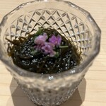 鮨つぐ - もずく酢はさっぱりとしている。紫蘇の花が添えられる