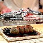 たかおか - 太刀魚の炙り棒鮨。 炙り棒鮨はこの店のスペシャリテです。 こうしてわざわざ手間をかけるとですね、熱くなった魚の脂が溶け出し、しゃりの間に潜り込むと同時にしゃり自体も人肌に温まるんです。 海苔は薄くパリンッした僕の好きな食感！ 大葉などの薬味がいい仕事してる。 この店の炙り鮨は、ふだん、鰯や鯵を使うことが多いのでラッキー。 僕は太刀魚が大好物なんです。 