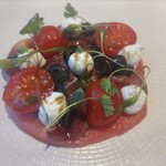 Swan - 料理写真:下に引いてあるのはスイカ！トマトとモッツァレラとオリーブのカルパッチョ　　　　スイカ甘くて美味しい♪意外にチーズと合う！