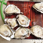 灯台茶屋 - 岩牡蠣の殻を外しています。手のひらサイズの殻の中には身がしっかりと詰まっています