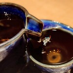 炉ノ骨頂 - 深い琥珀色した古酒は、色と同じくまろやかで深い味わい
      左のボトル(徳利？)から、右のお猪口へ注いでいただきます