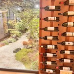 炭火焼肉 牛仁 - 店を入るとガラス越しに庭が見え、その横にはワイン