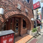 麗郷 渋谷店 - 外観　煉瓦作りが経年で風格。窓の丸い飾りがモダン。