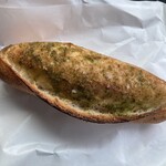 天宮のパン - 見事なお姿のガーリックバターのプチバケット。バターとガーリックの緑とお塩のトッピングに、少し焦げたパンの焼き具合がそそります。