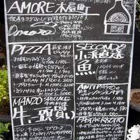 アモーレ 木屋町 - 店前にあったボードです。色々と書いてありますね。ＰＩＺＺＡは薪窯焼き、魚は小浜直送、肉は牛一頭買い．．．．色々とこだわりがありそうですよ。