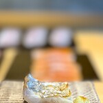 鮨 三心 - タチウオ燻し。 桜のチップで燻された皮目から内側へと火入れと味わいのグラデーションを描きます。  燻し置きされており、皮目の薫香と味わいはキャラメリゼされたかのようで、シブい香りと淡い旨みに唸りました。  これだけで1合消えそうです。 危ない、危ない。