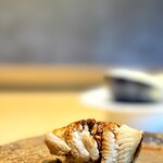 鮨 三心 - アナゴ（追加）。 コースになく追加メニューで見つけたタネ。 これだけの鮨をだすなら、どうしてもこれを食べなきゃと思ったので。  予想通り、とてつもなく旨い握りでした。 本日、一番温度が高いシャリで少し熱いくらいのアナゴ。  鮨は熱々が旨いって、冗談のような真実を伝えてきます。