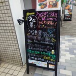 うな賀 - 階段下のA型黒板看板。