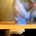 鮨 三心 - 酢イカ（鮨）。 イカの味わいはほぼ包丁で決まる。 パキッとした味わいは縦包丁。 流行りのベチョっとしたイカが嫌い。 三心流は酢で〆めて芸術的な縦包丁。 そして裏には斜め包丁。 これは、、一瞬、脳がバグるがすぐに味覚を取り戻し、驚きの旨さを認識して再び脳がバグる。 東京の鮨好きなら知らない人はいない老舗、「㐂寿司」の酢イカを彷彿とさせる、シブい握りに唸った。