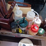 いきなりステーキ - 卓上仕切り上に数々の味変ソース類