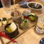 田っくんのサテライト商店 - ◯本日のおまかせ6種盛り合わせ¥1,200
      左手前から右に
      ・自家製の蒸し胡麻豆腐
      ・スギのごまだれ漬け
      ・夏野菜の酢醤油漬け
      ・浸し豆
      ・かしわ松笠焼き
      ・鶏ささみの天ぷらオリーブ醤油